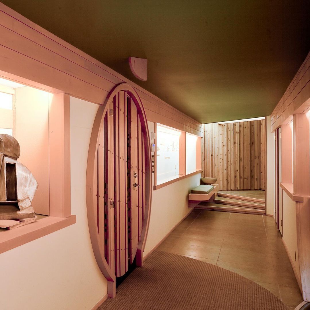 Round dining sphere surrounded by floor-to-ceiling glass with sculpted wooden ceiling elements overhead.