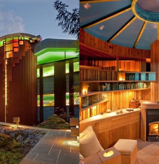 The tower form of the Hunter Residence seen at dusk, warm windows glowing against the forest.